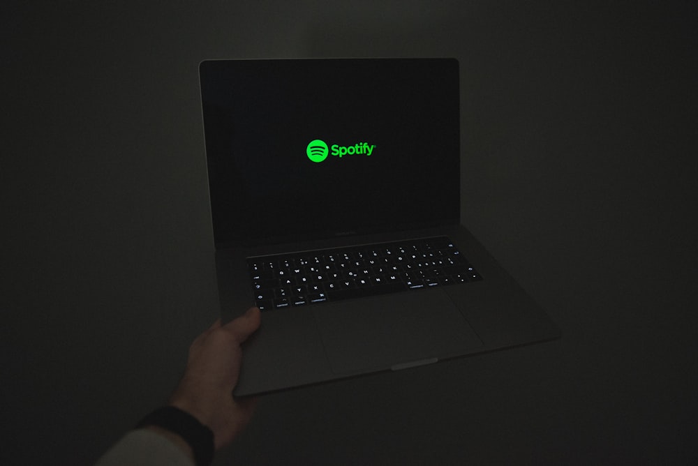 a person holding a laptop in the dark