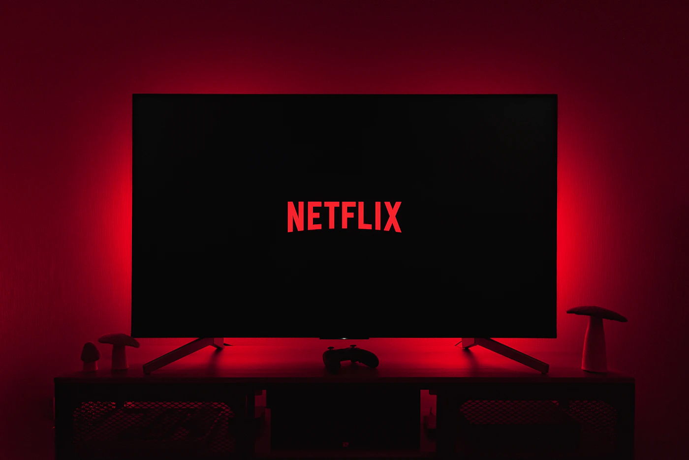 A TV glowing with a streaming logo in the dark