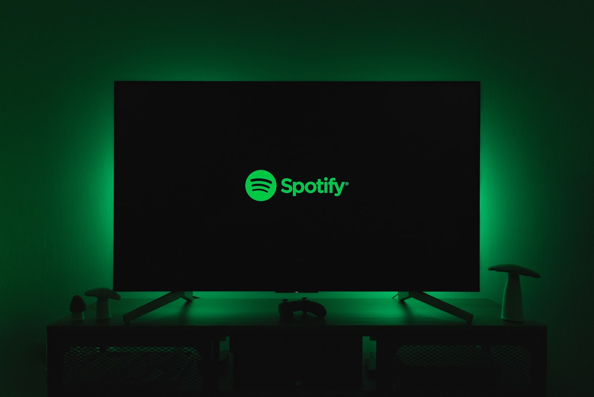 Spotify logo illuminated on a screen representing the streaming giant's record-breaking quarterly earnings
