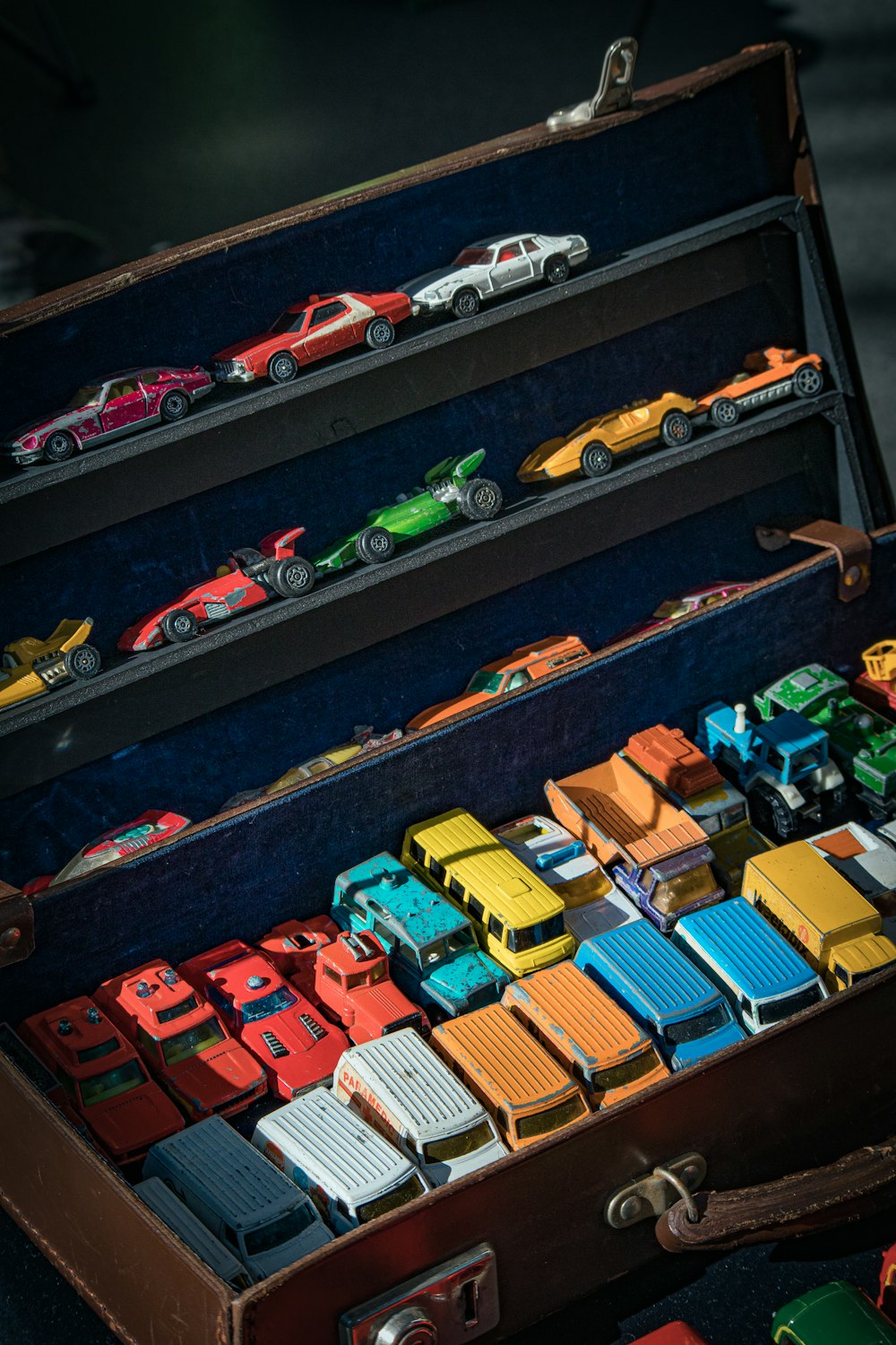 a suitcase filled with toy cars sitting on top of a table
