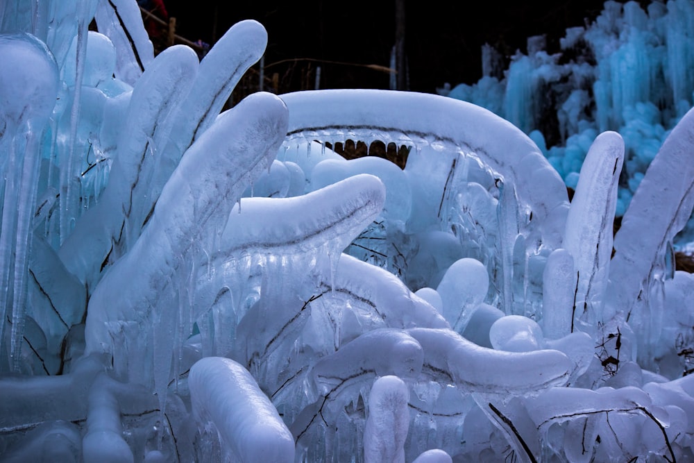 a car covered in ice and snow next to a forest