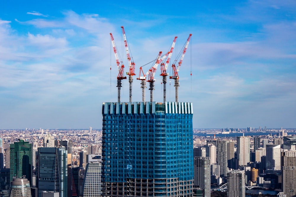 a tall building with cranes on top of it