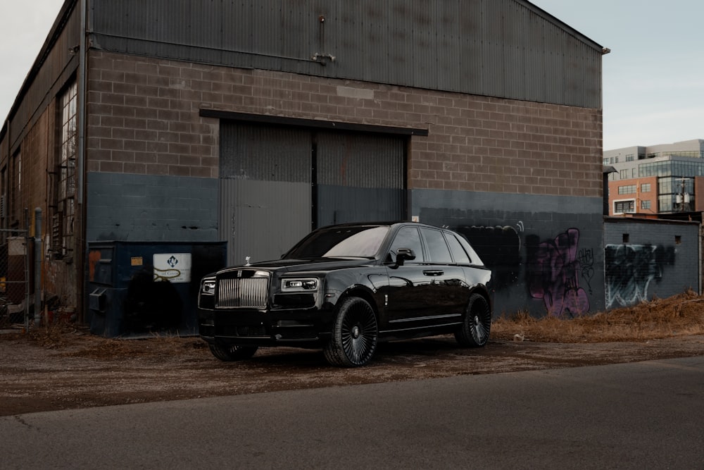 a black suv parked in front of a building