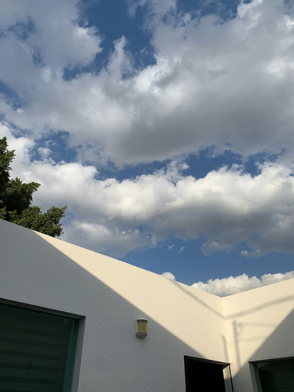 a white building with two garage doors and a sky background