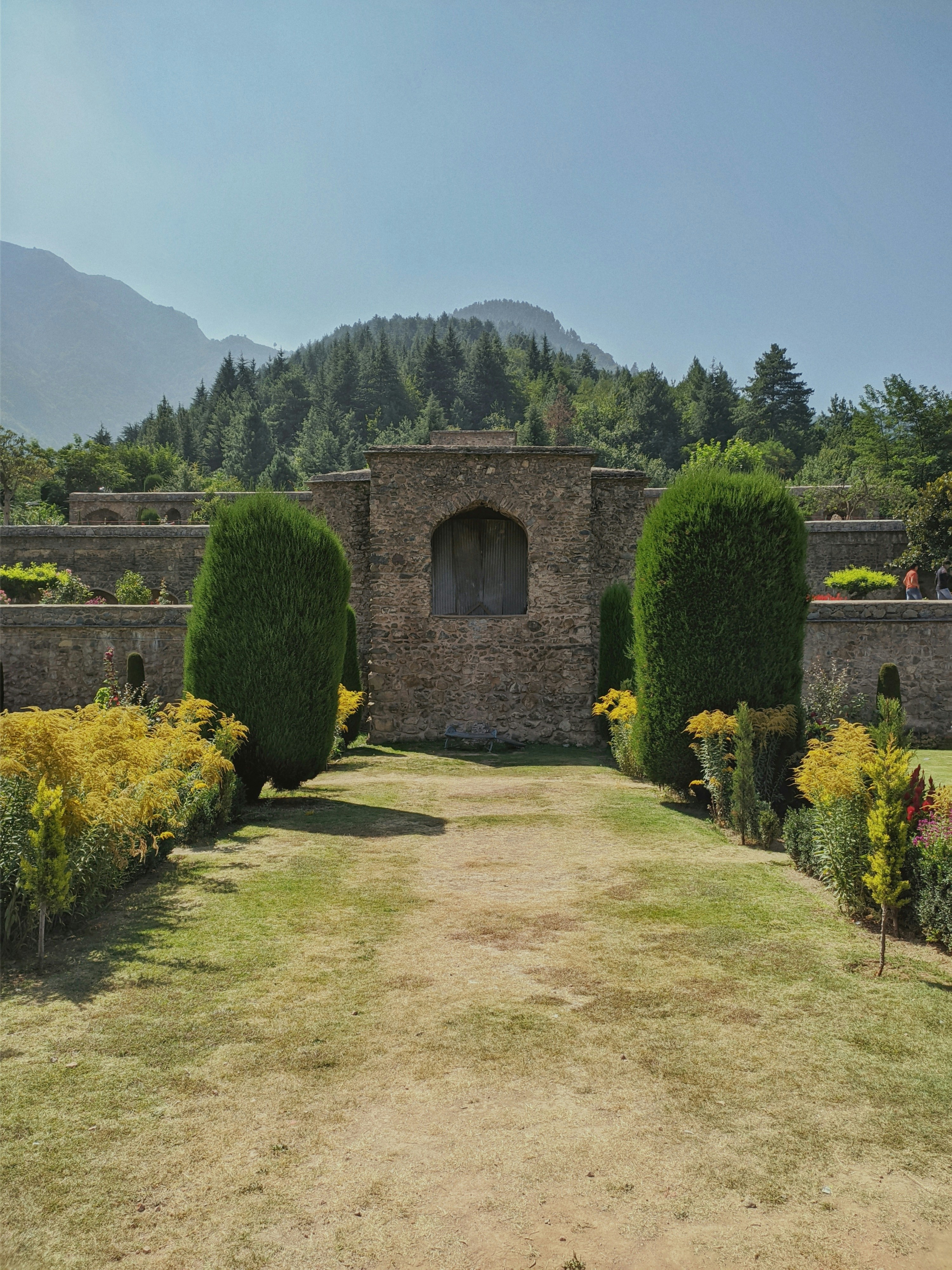 a stone building surrounded by lush green trees
