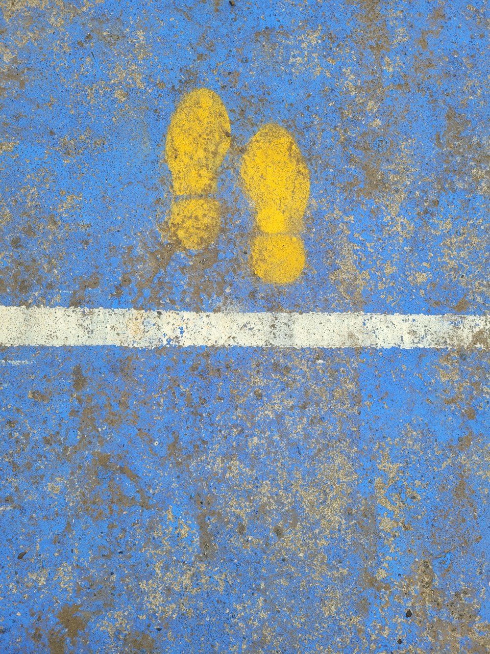 a pair of yellow shoes sitting on top of a blue floor