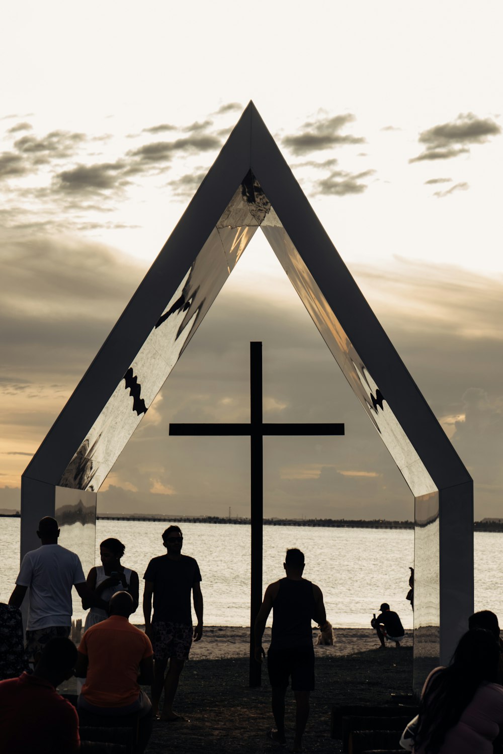 a group of people standing in front of a cross