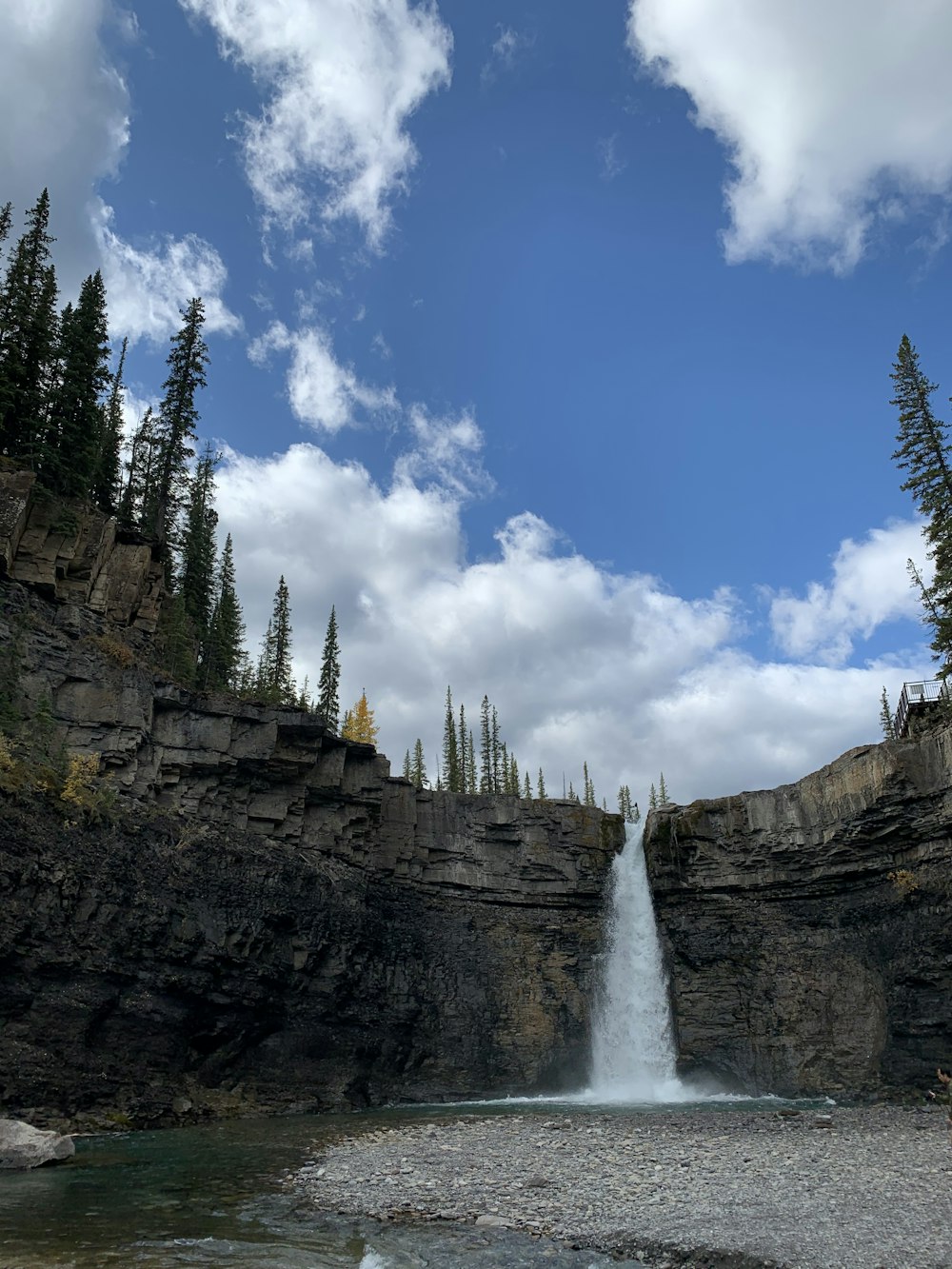 a waterfall with a large waterfall cascading down it's side