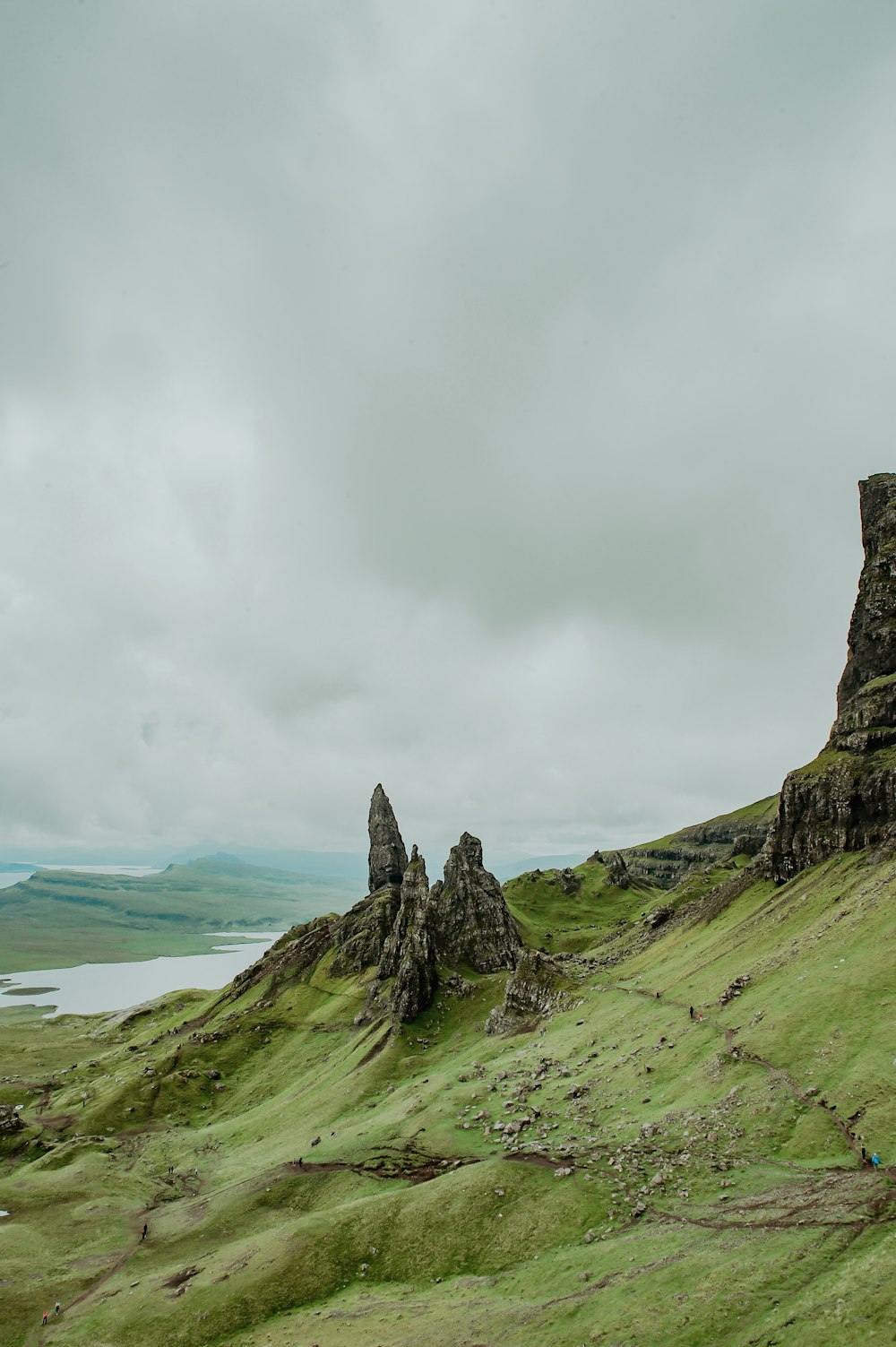 a couple of rocks sitting on top of a lush green hillside