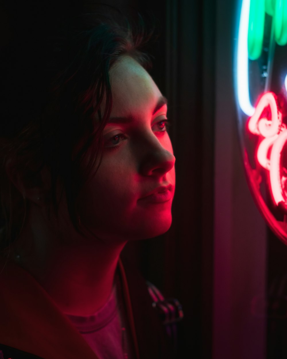 a woman standing in front of a neon sign