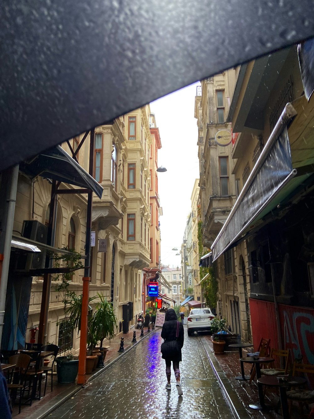 a person walking down a street in the rain