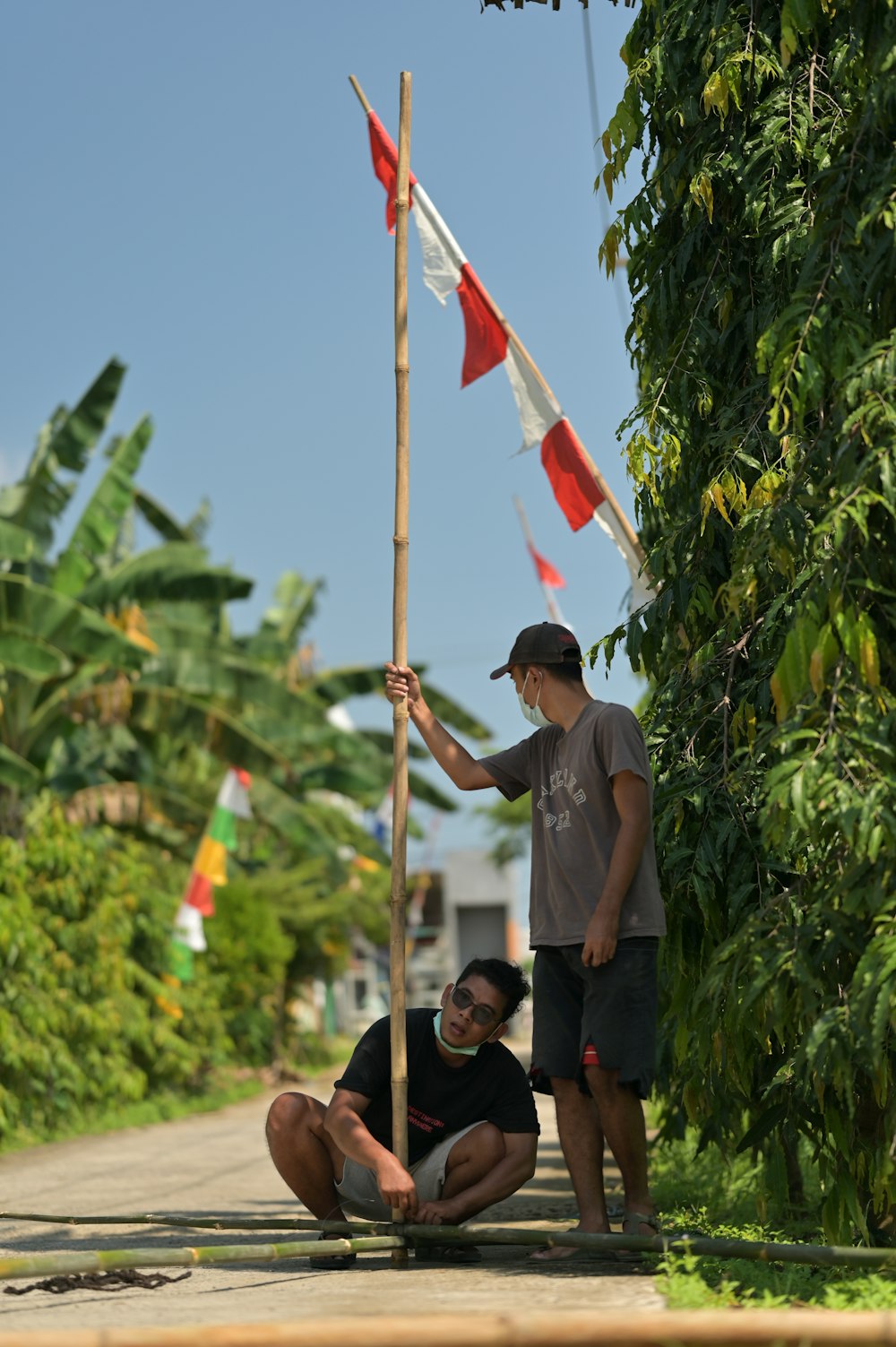 a man kneeling down next to a man holding a flag