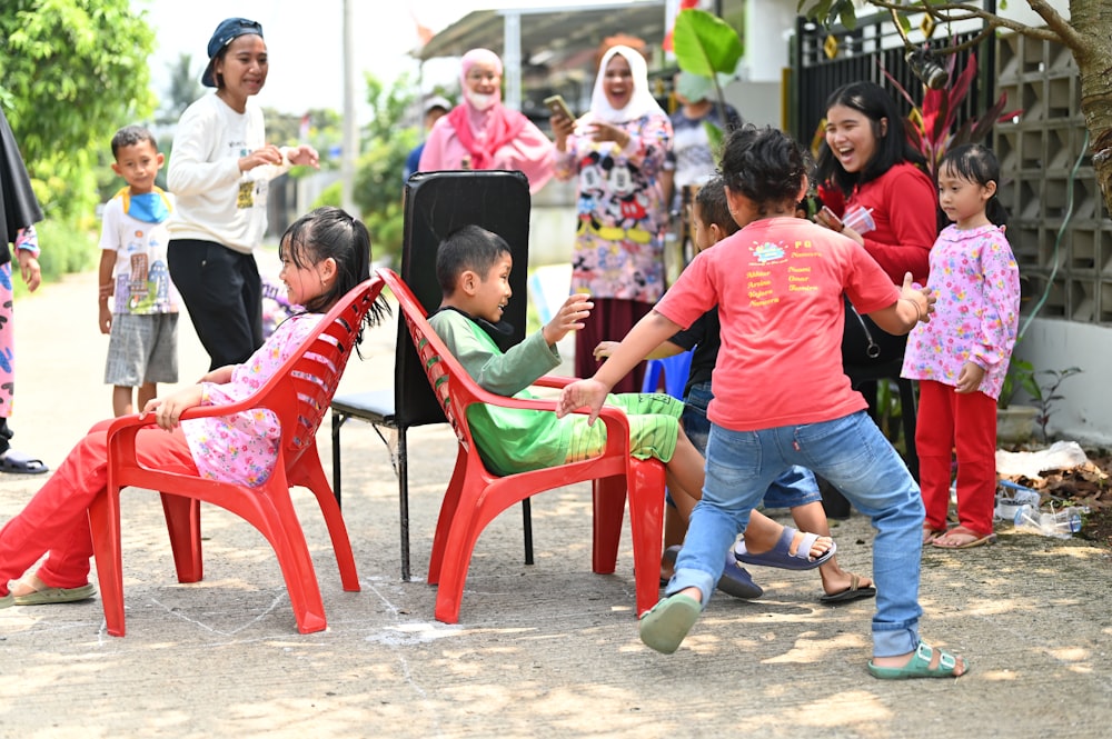 a group of children playing around a red chair