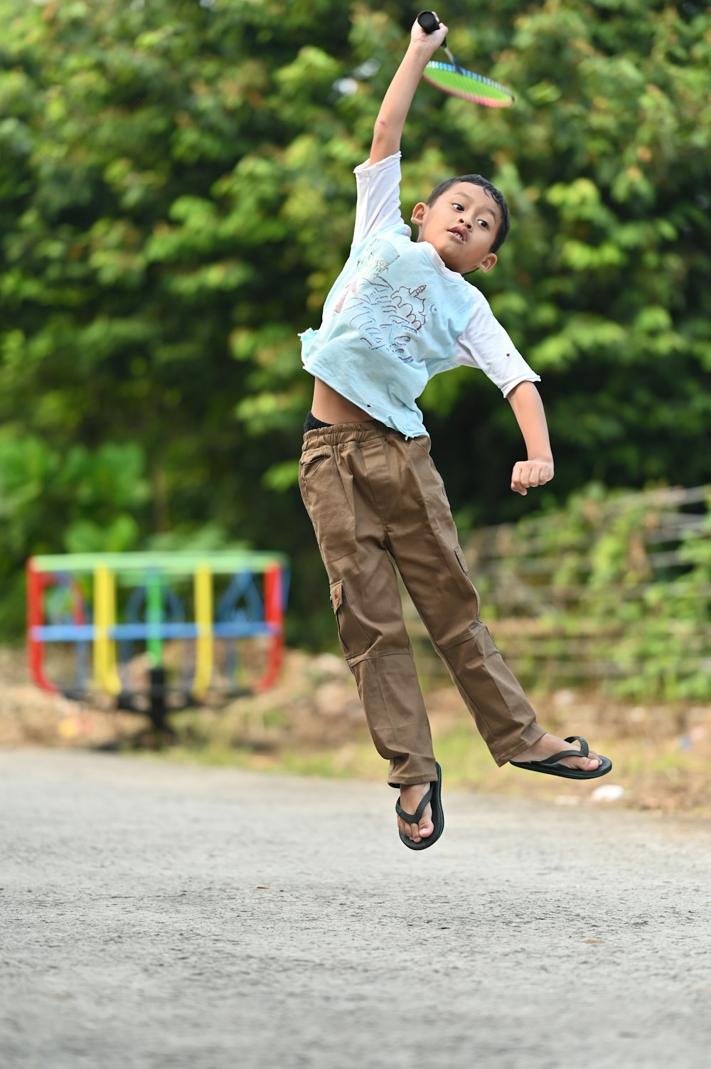 a young boy jumping in the air with a frisbee