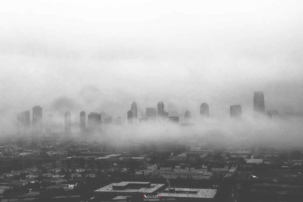 a black and white photo of a city in the fog