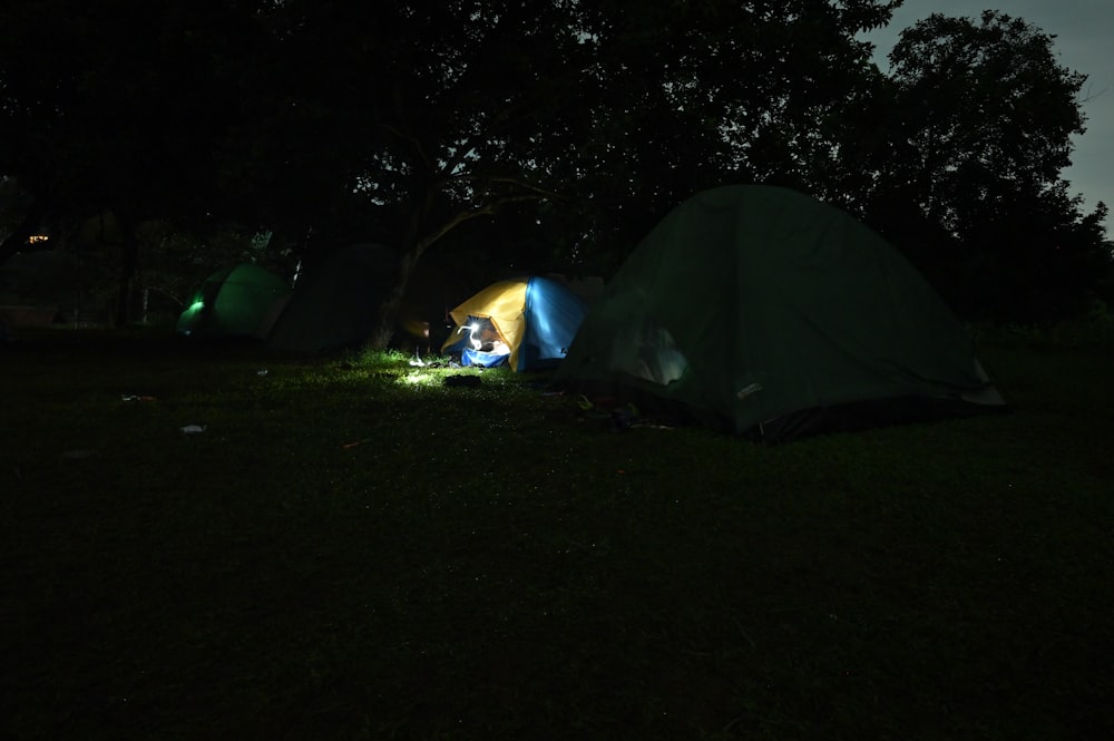 a couple of tents sitting in the grass at night