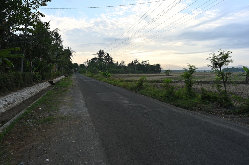 an empty road with power lines in the distance