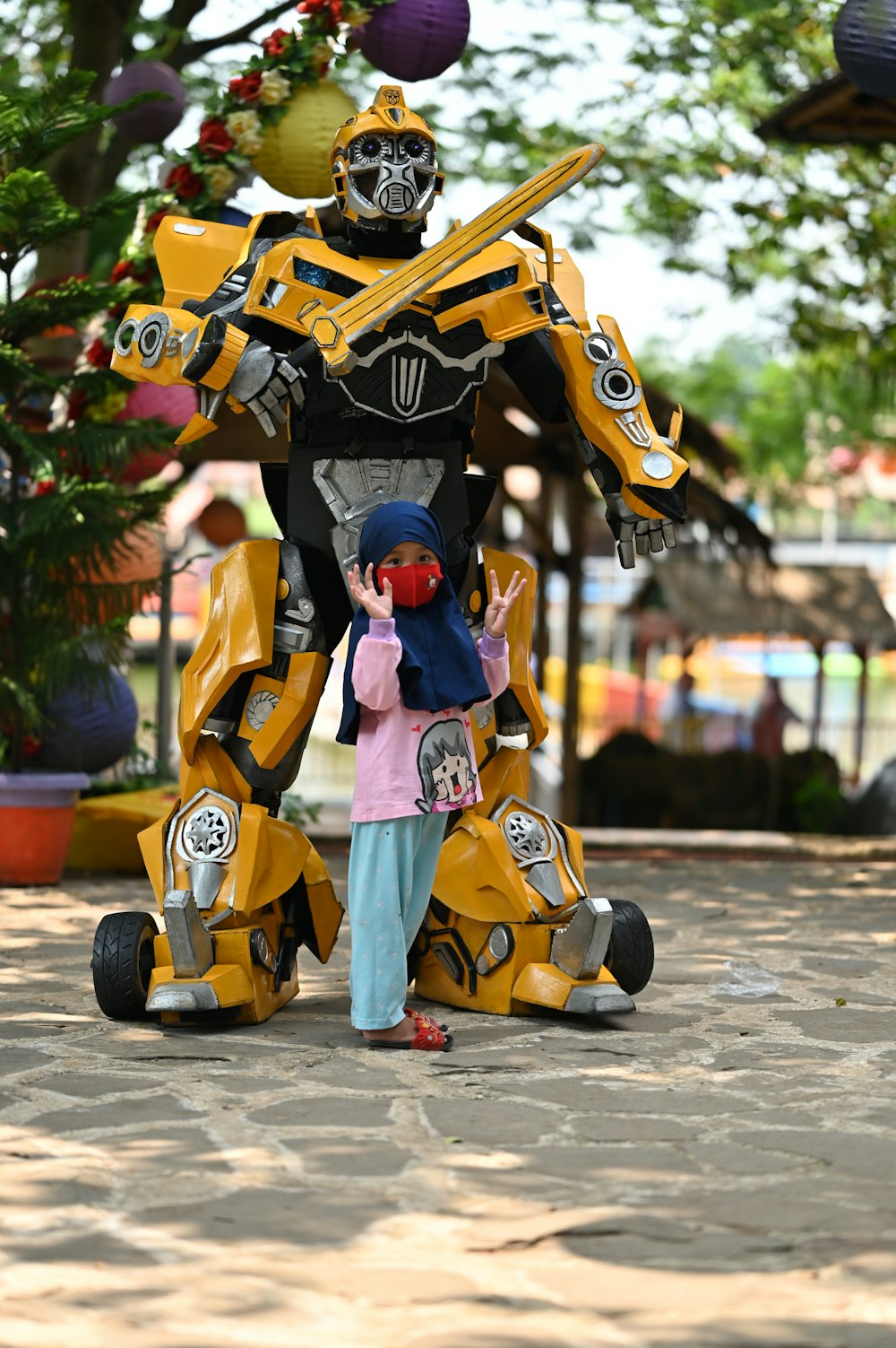 a little girl standing next to a giant robot