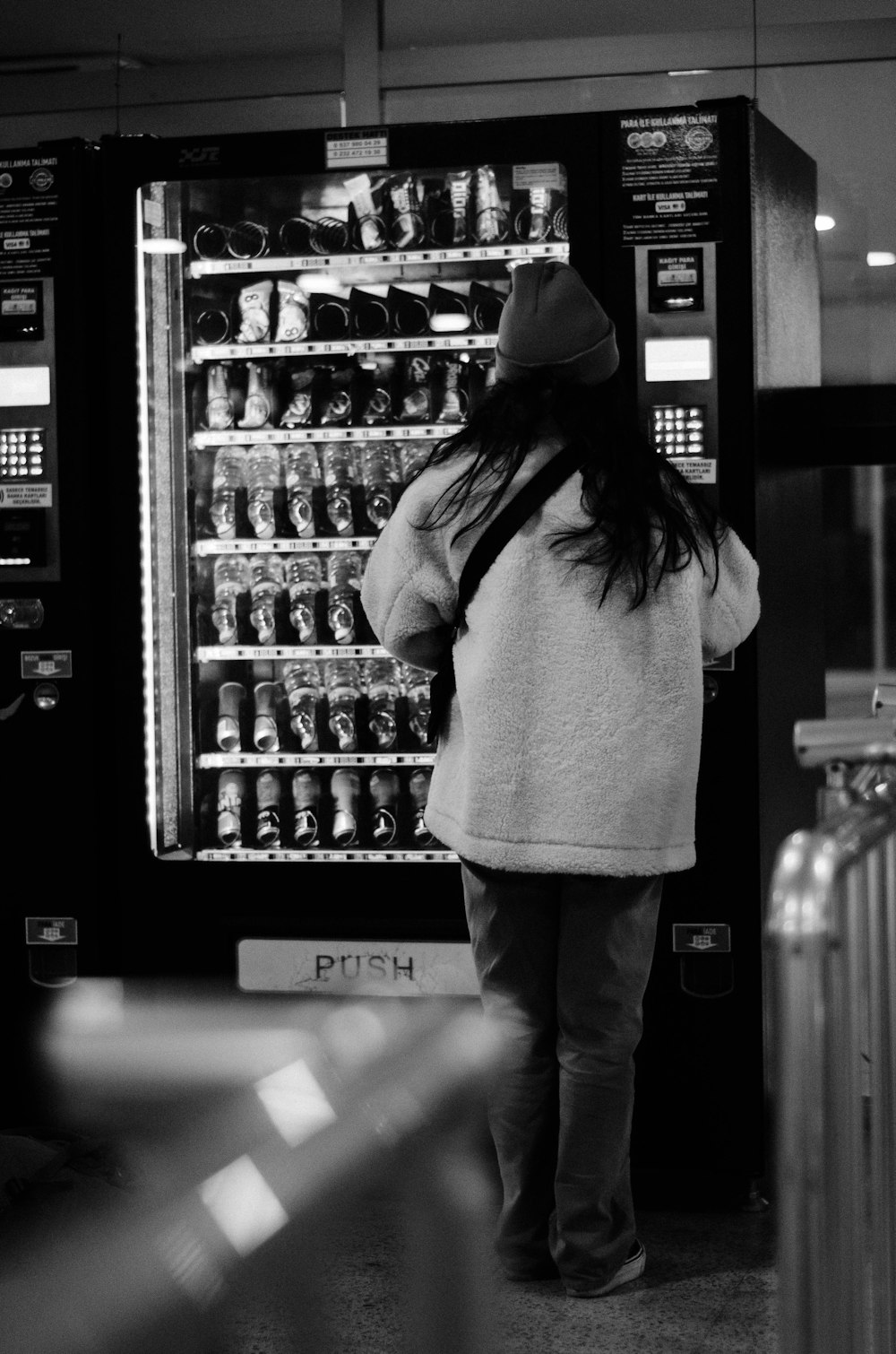 a woman standing in front of a vending machine