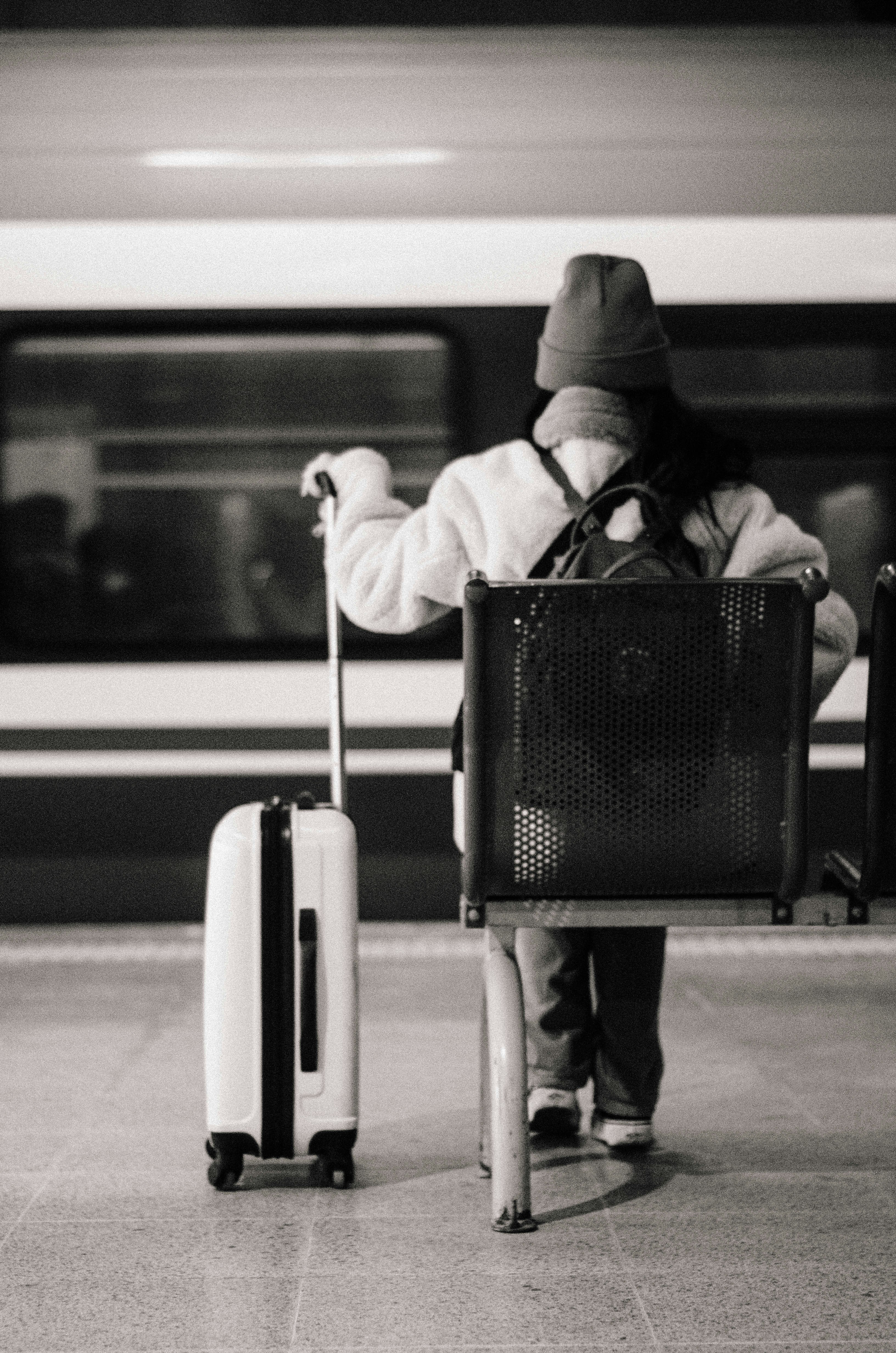 A person with a suitcase and a bag waiting for a train photo Free Junkie Image on Unsplash