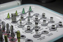 Close-up of dental tools and implants arranged neatly on a sterile tray.
