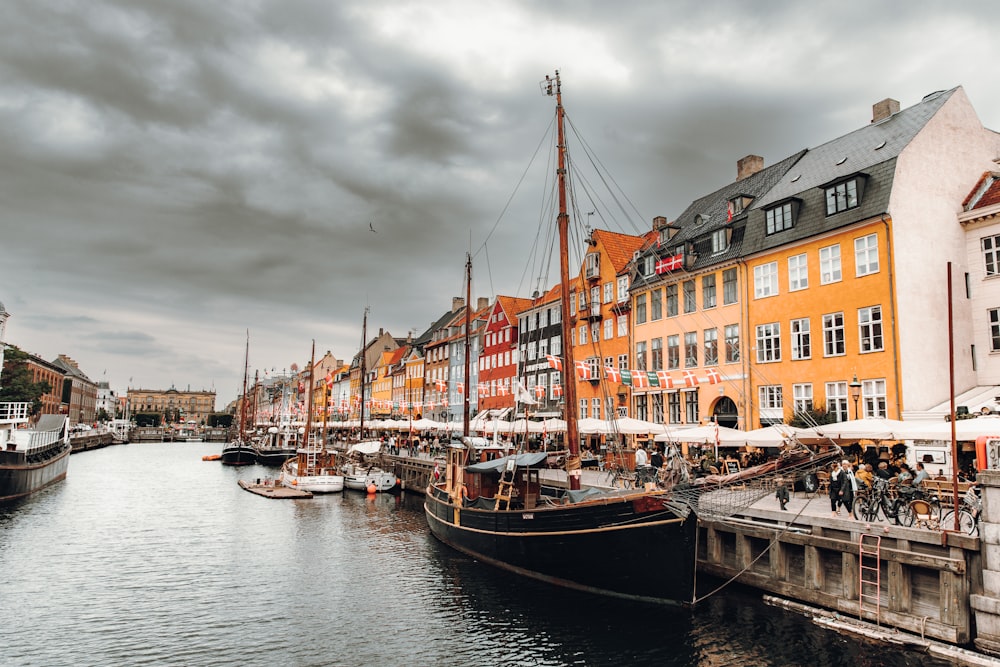 a boat is docked in the water next to a row of buildings