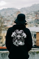a person wearing a black hoodie with a picture of a gorilla on it