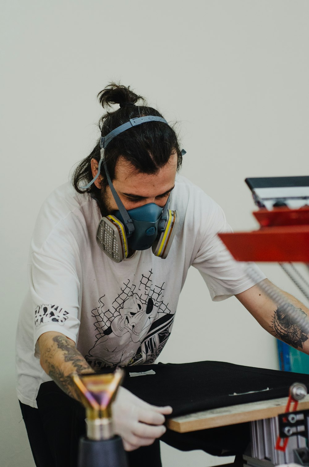 a man wearing a gas mask and holding a paintbrush