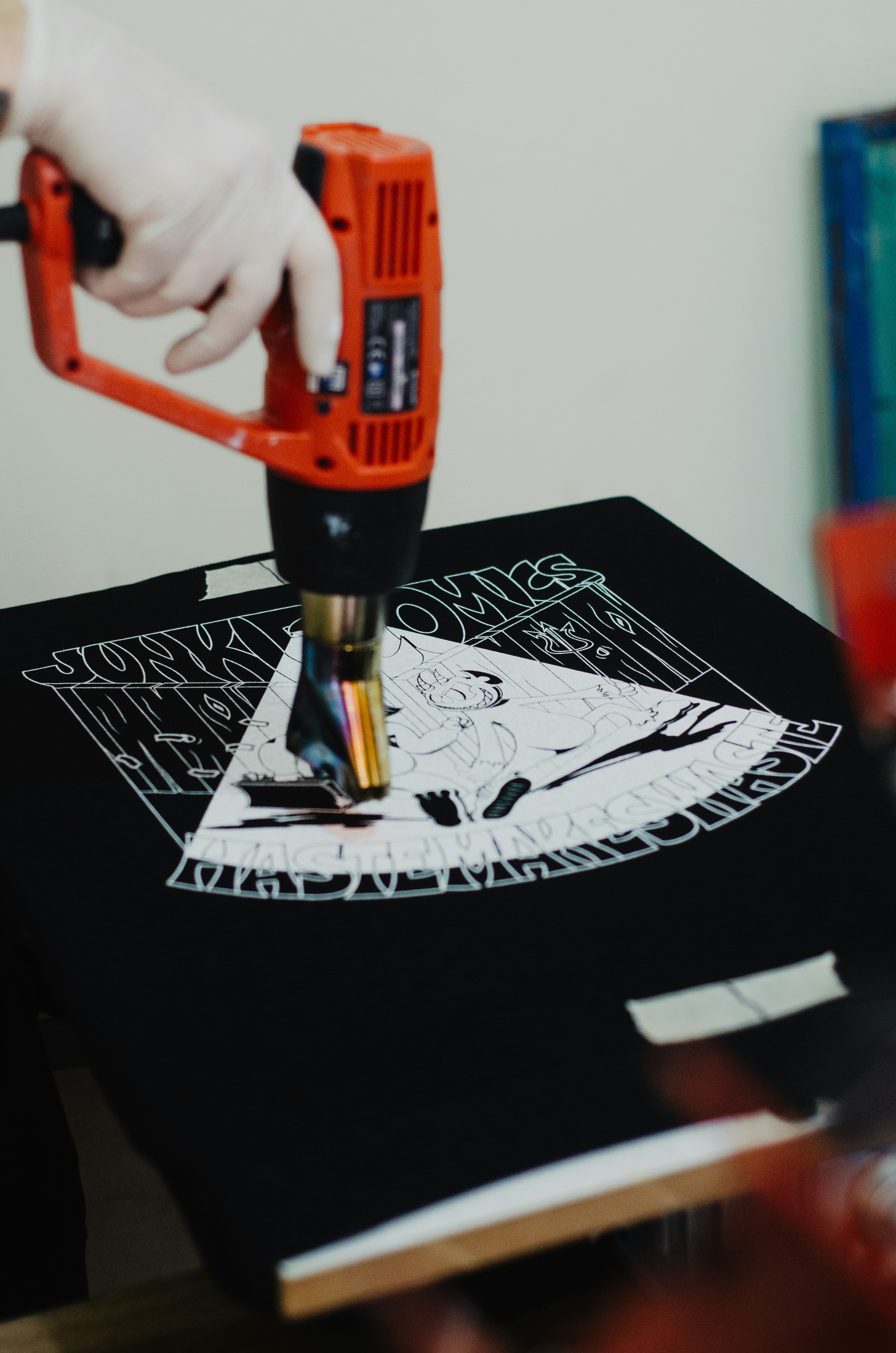 a person using a drill gun on a t - shirt
