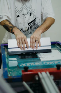 a man with a tattoo on his arm using a machine