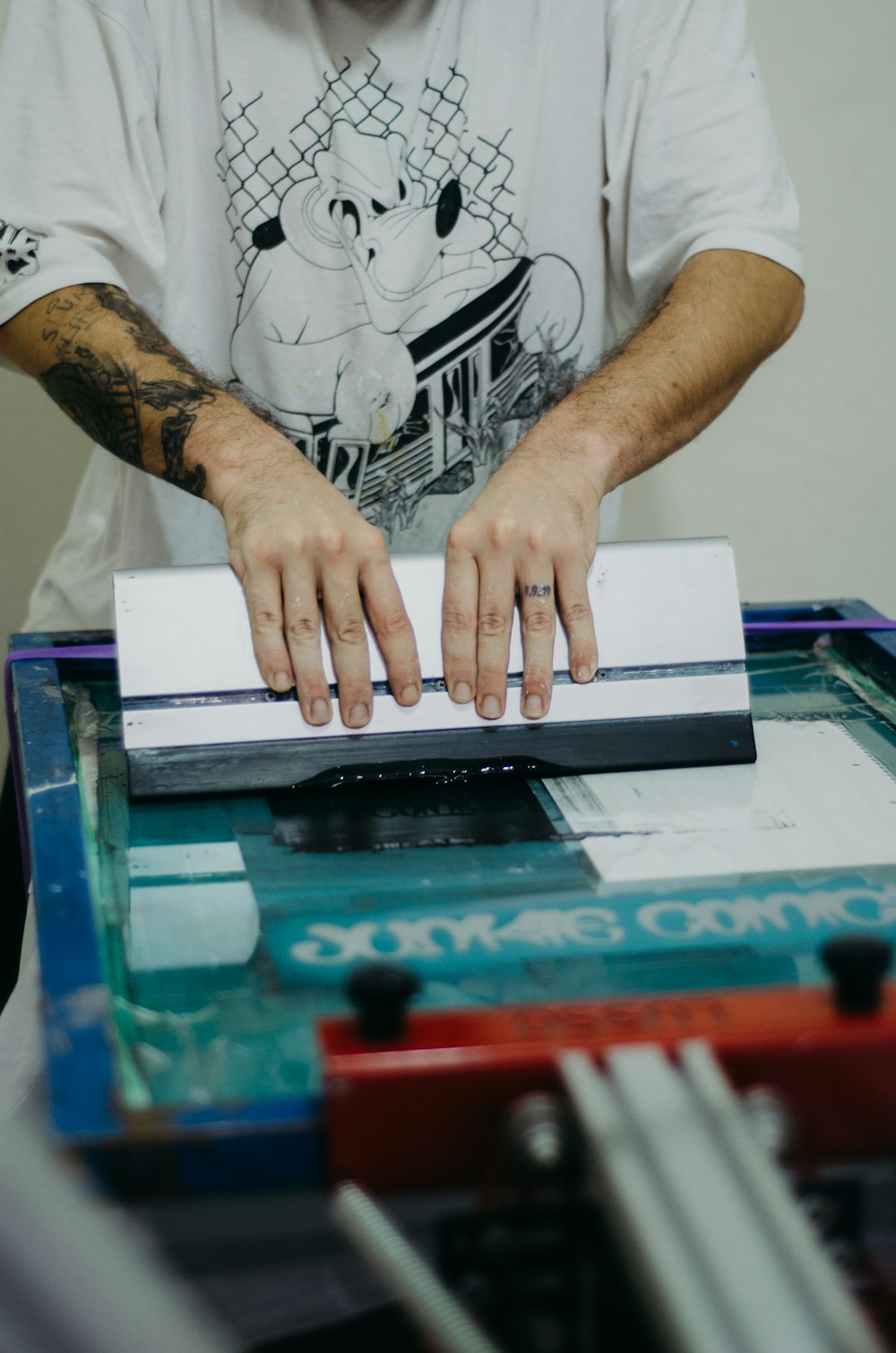 a man with a tattoo on his arm using a machine