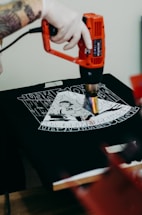 a man with a tattoo on his arm using a drill