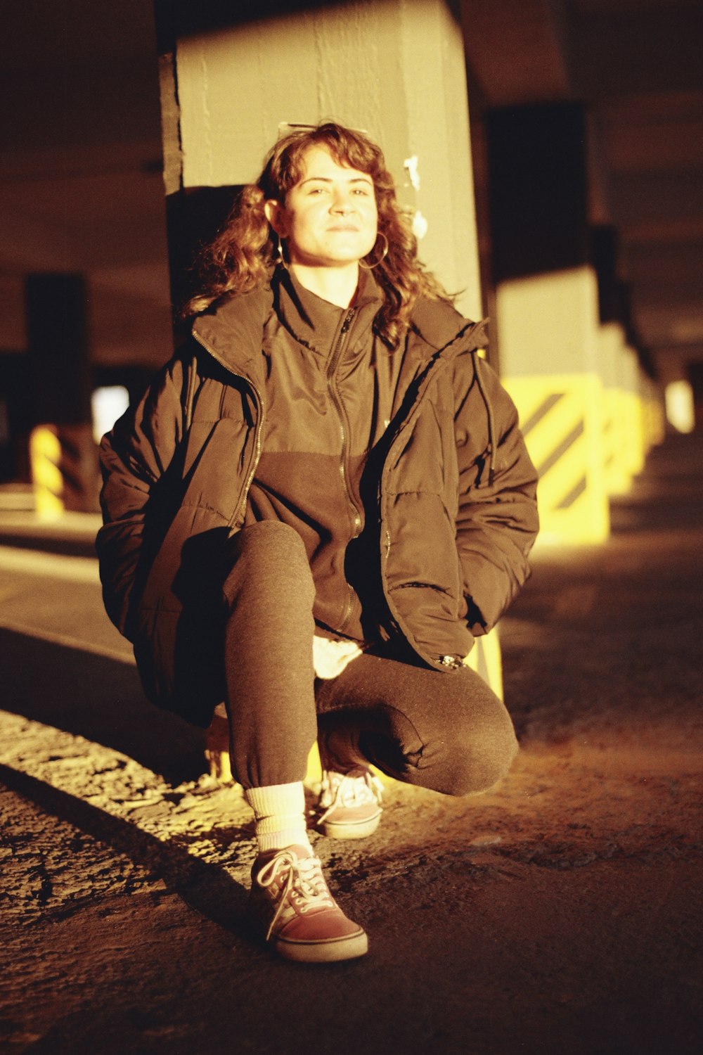 a woman sitting on the ground in a parking garage