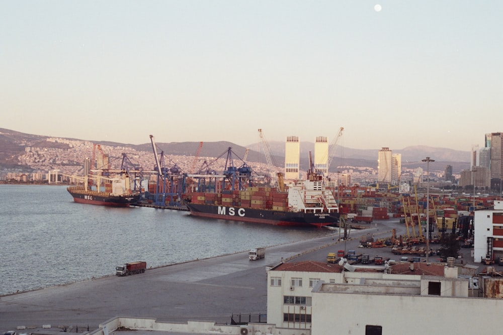 a large cargo ship in a harbor with a city in the background