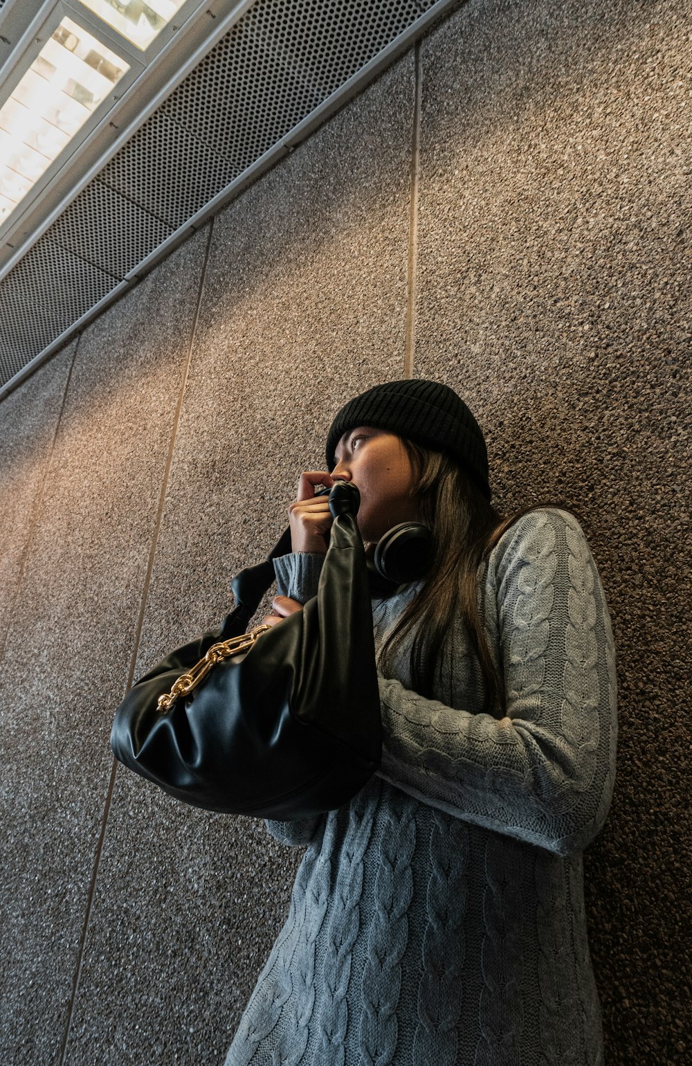a woman talking on a cell phone while holding a purse