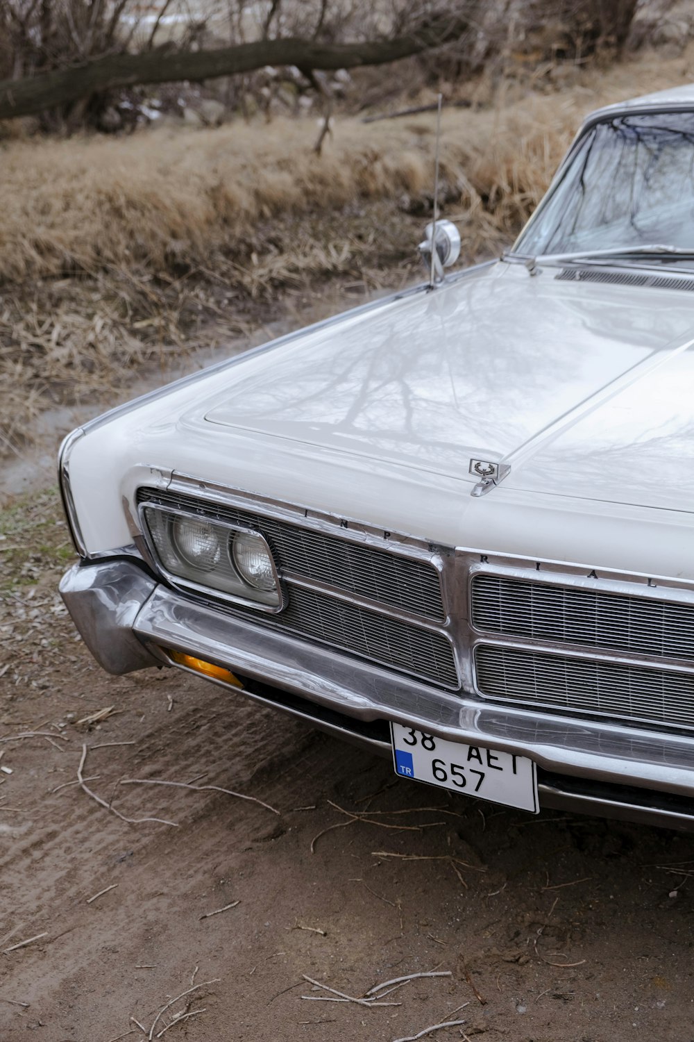 a white car parked on a dirt road