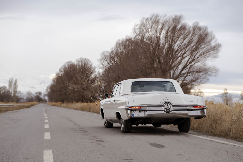 an old car is parked on the side of the road