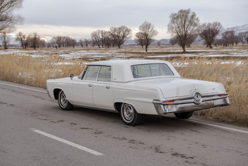 an old car is parked on the side of the road