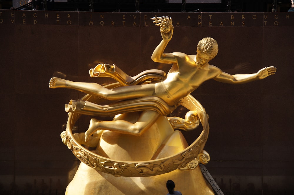 a golden statue of a man and a woman on a boat