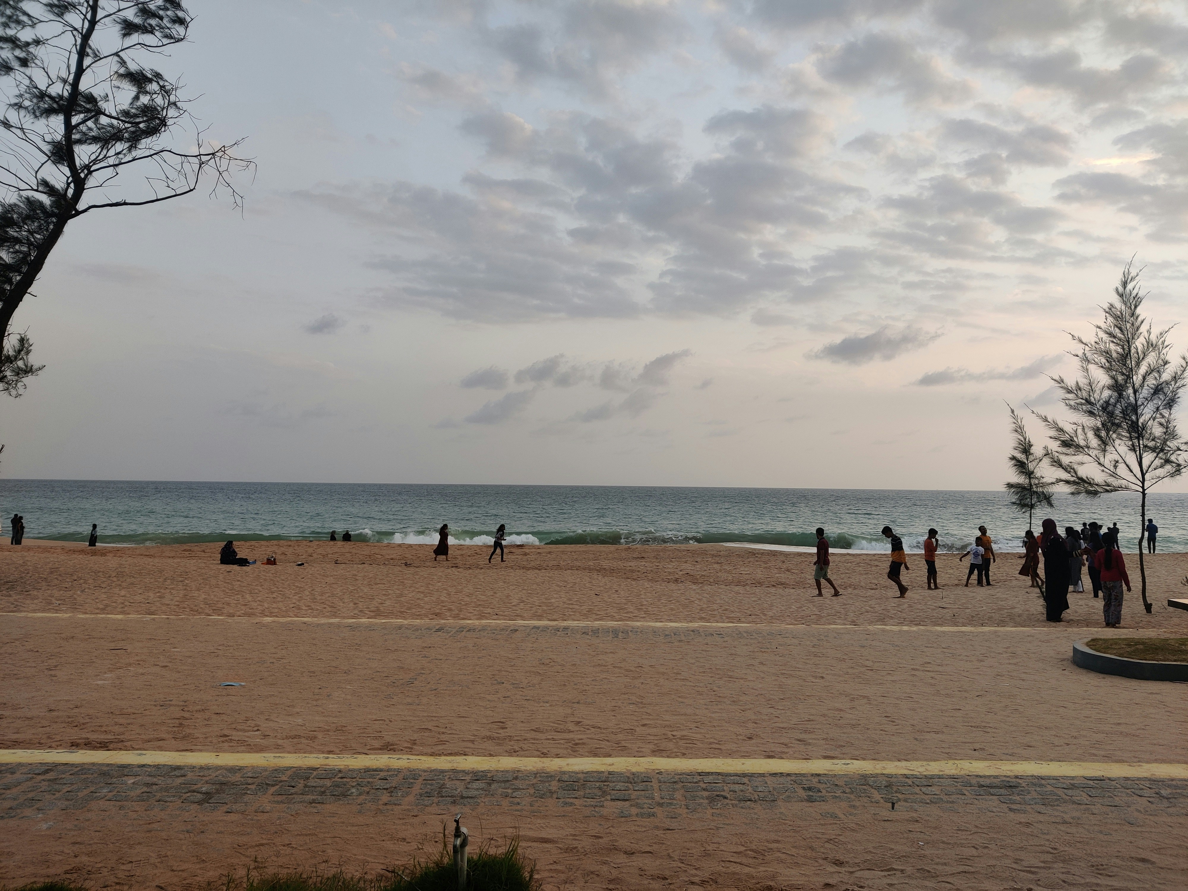 a group of people standing on top of a sandy beach