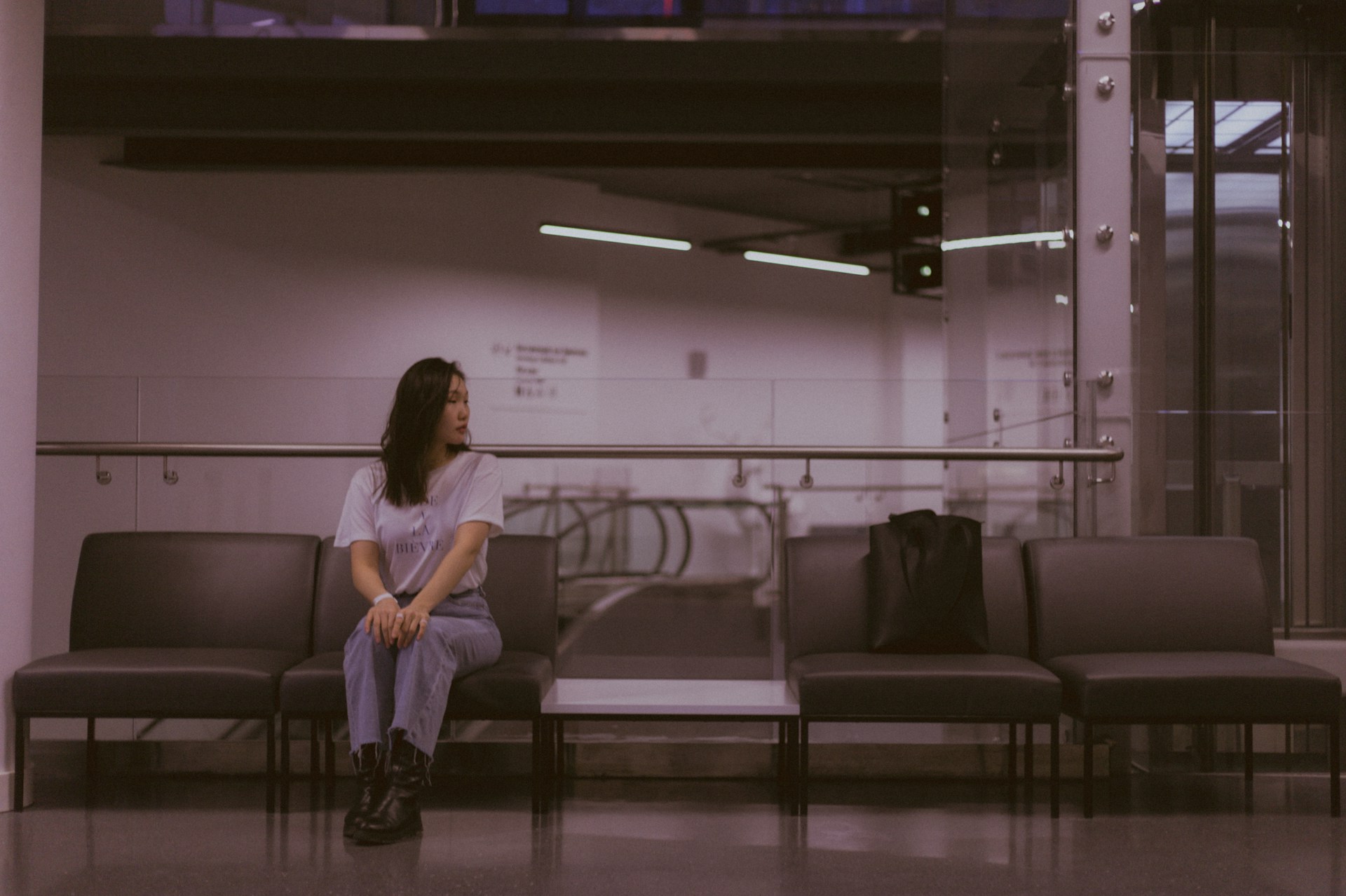 a woman sitting on a bench in a waiting area