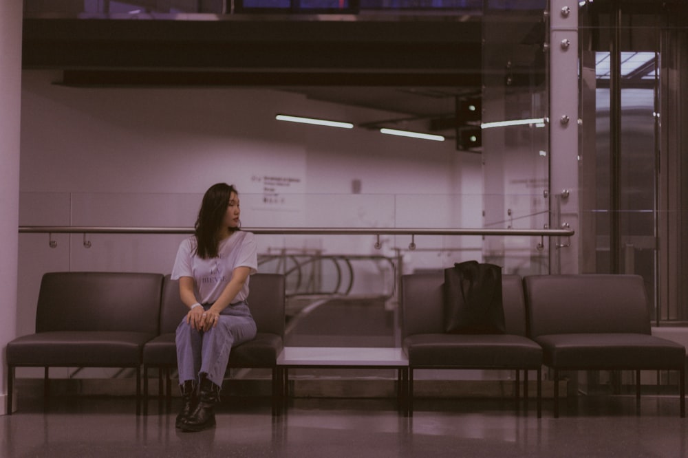 a woman sitting on a bench in a waiting area
