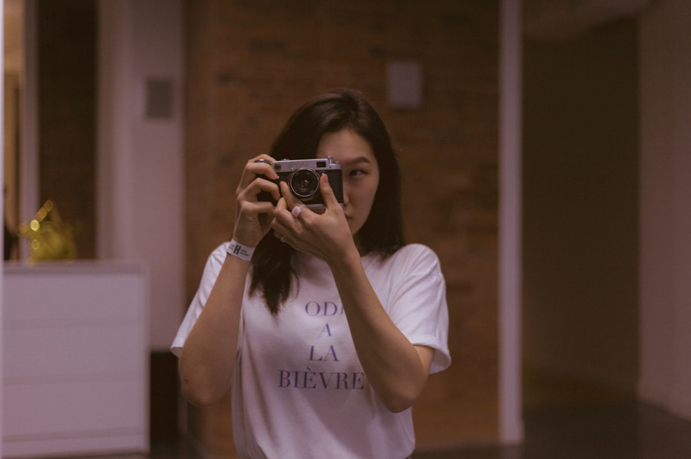 a woman taking a picture of herself in a mirror