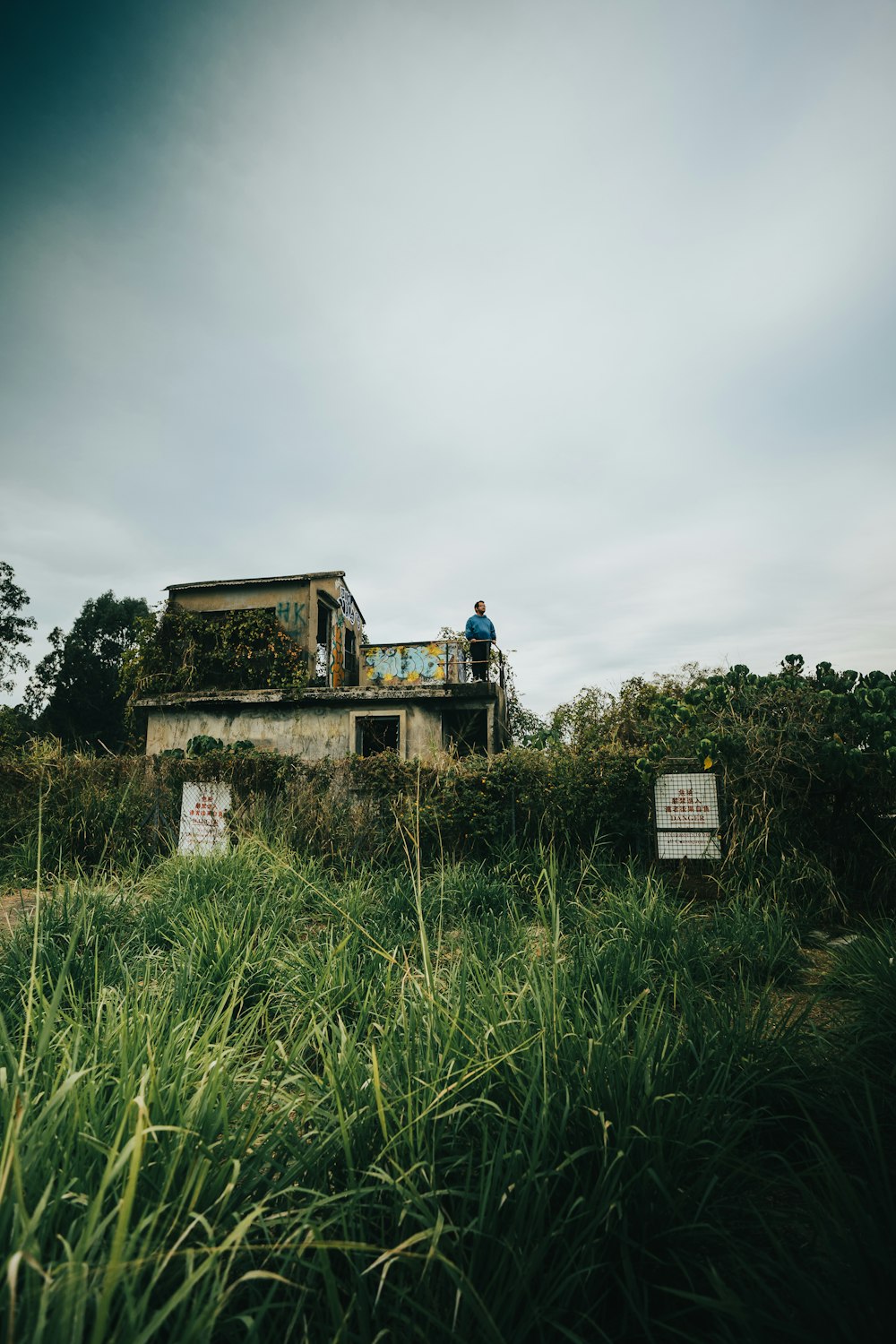 a man standing on top of a building in a field