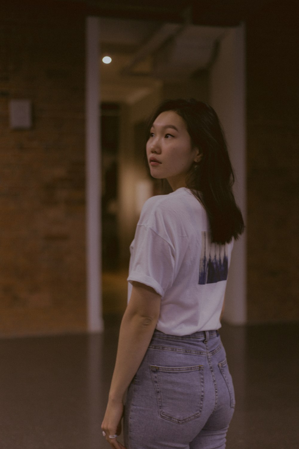 a woman standing in an empty room with her back to the camera