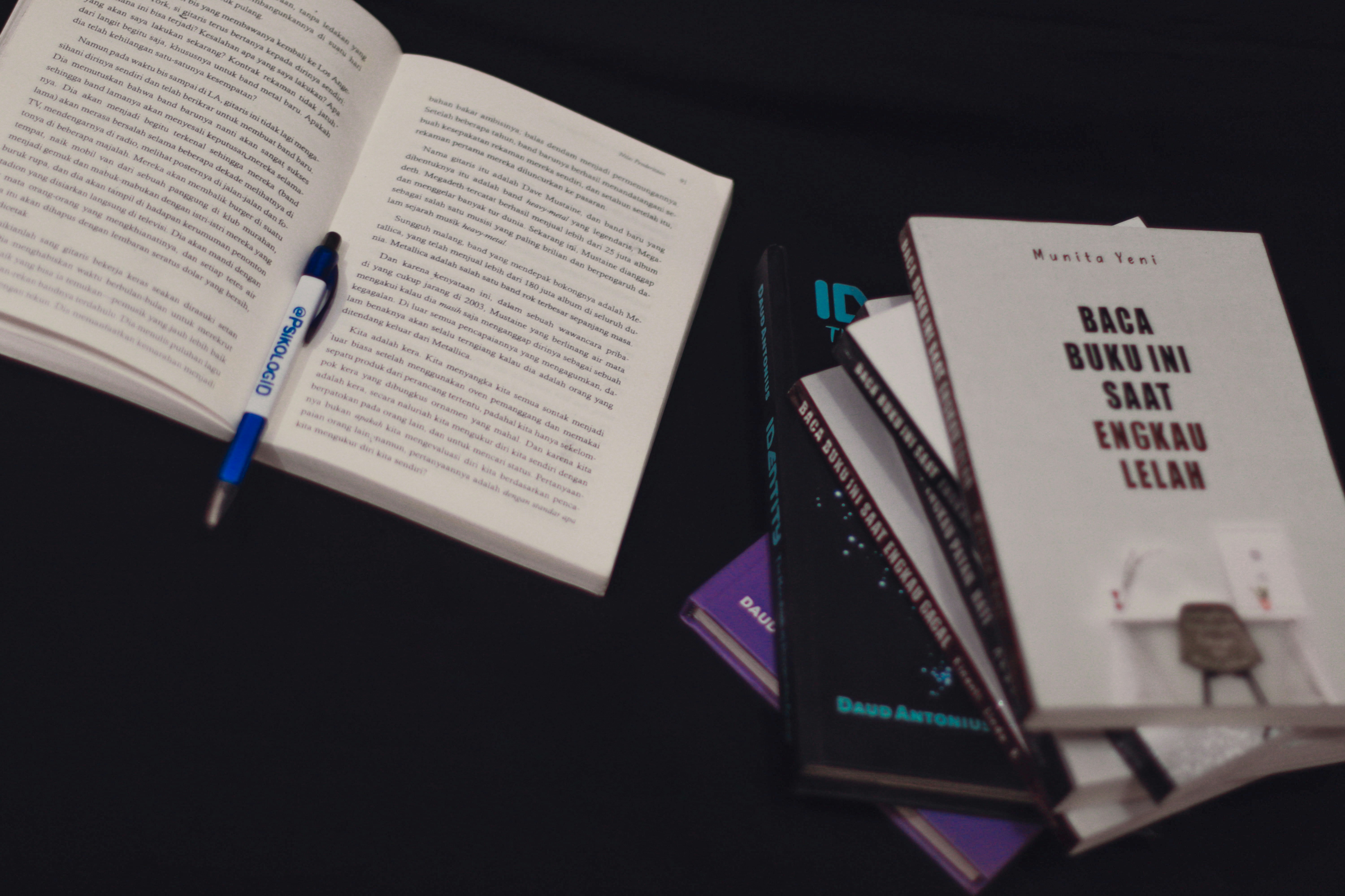 a stack of books and a pen on a table