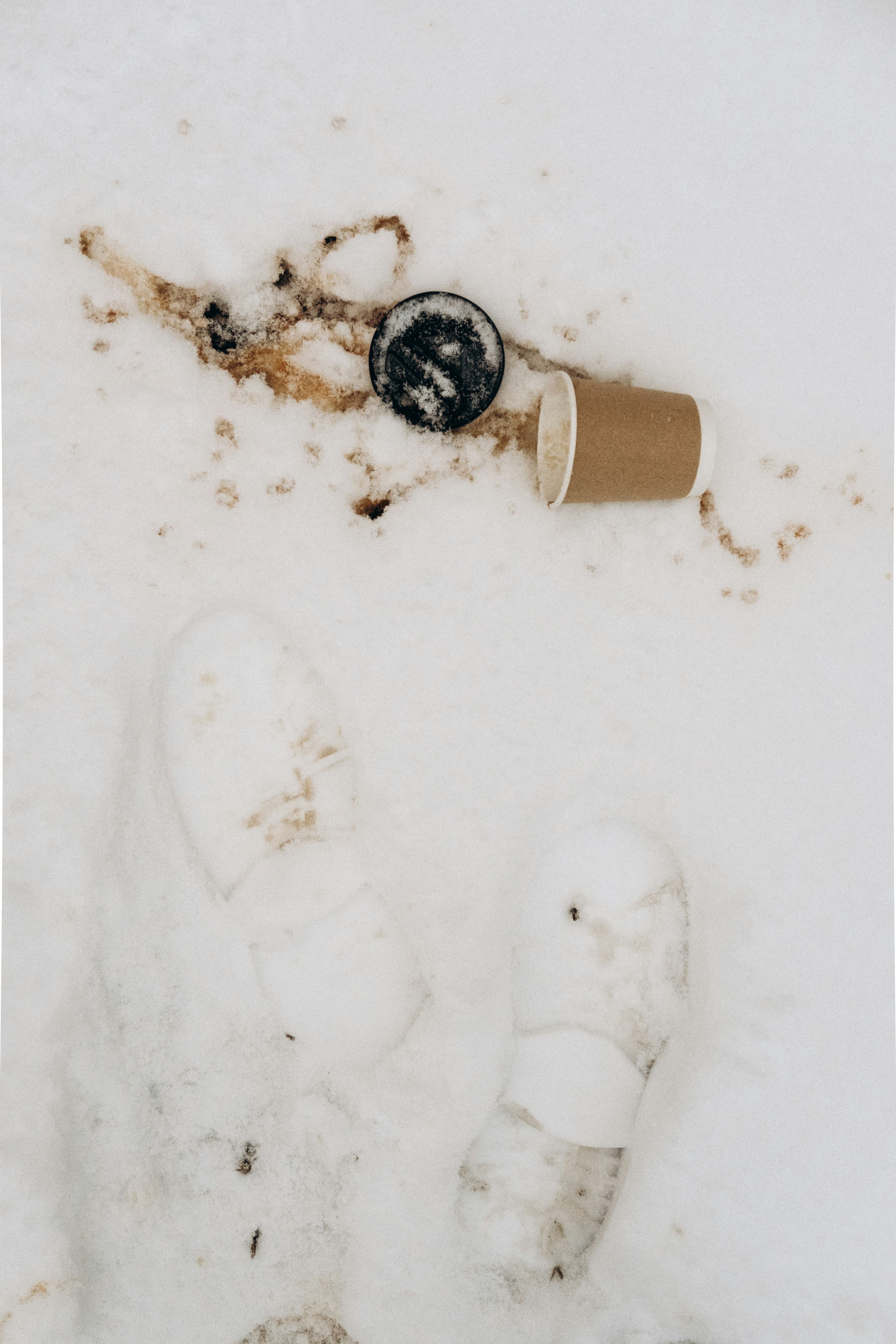 a person standing in the snow next to a cup of coffee