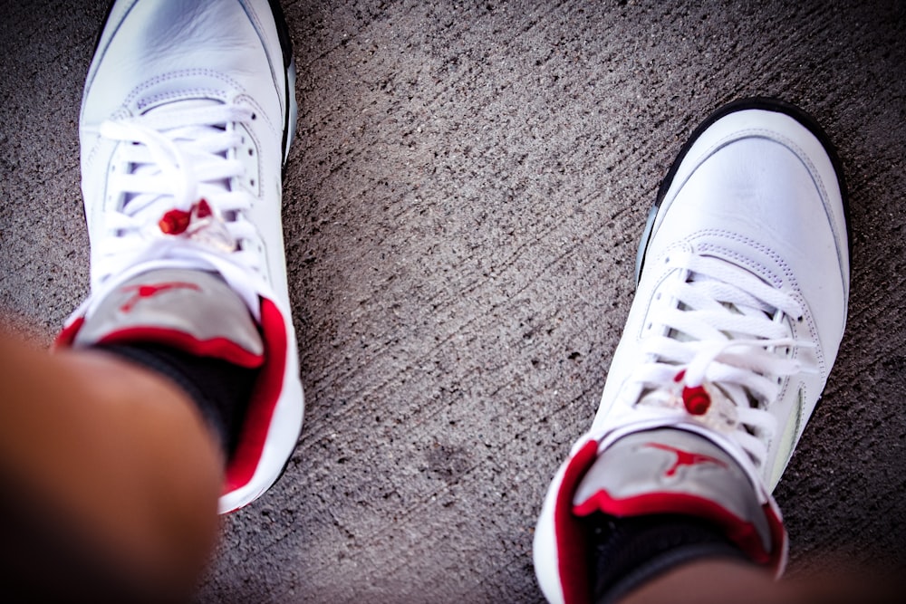 a pair of white sneakers with red accents