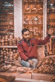 a man sitting in front of a display of gold items