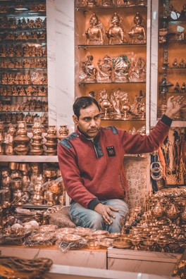 a man sitting in front of a display of gold items